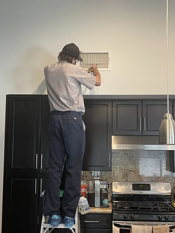 Technician inspecting an air vent during HVAC service in Crawfordville